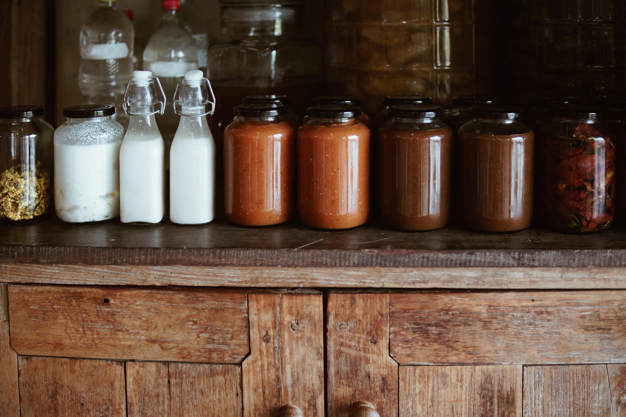Jarred sauces lined on wooden shelf