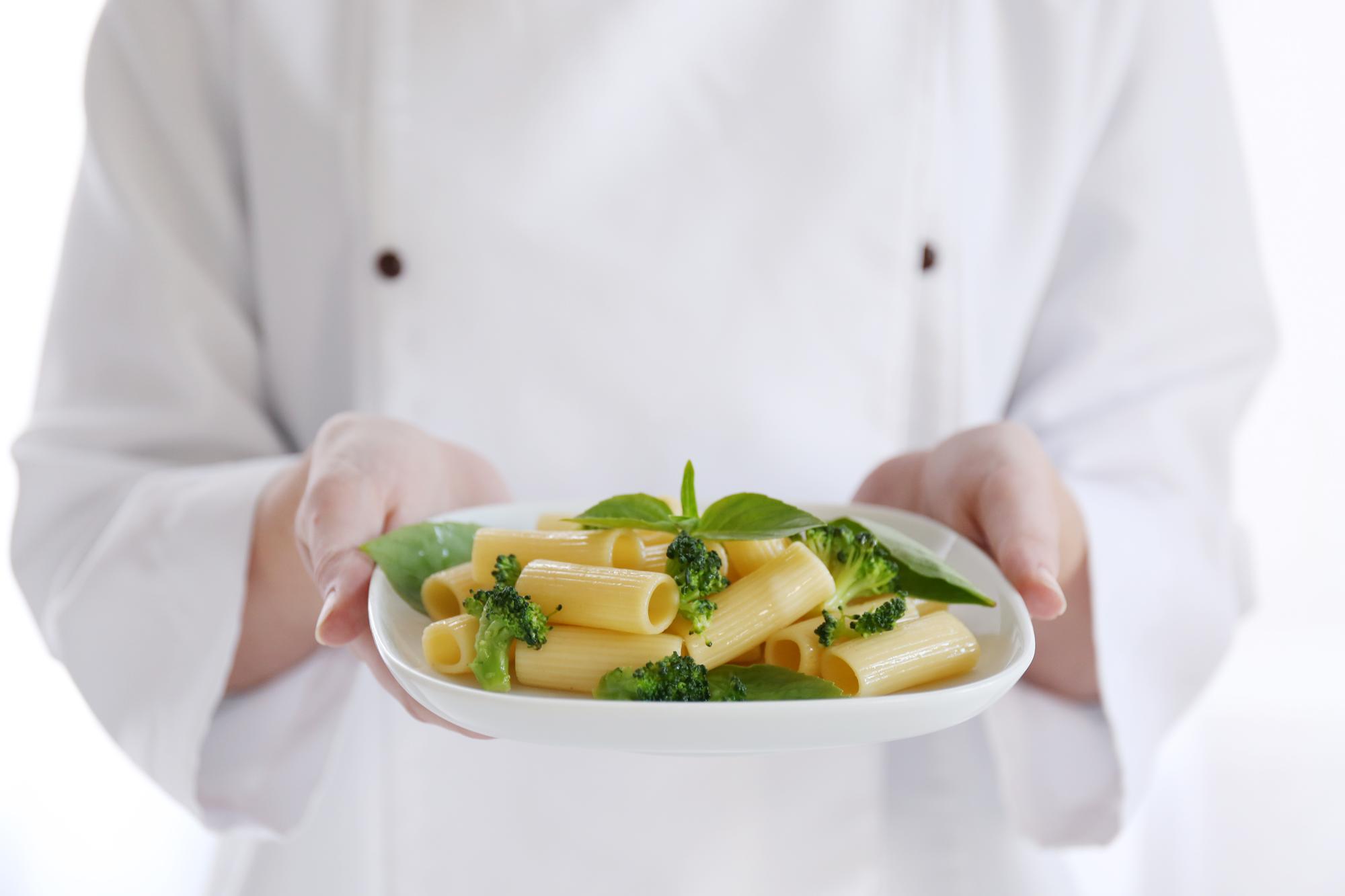 Chef arranging plated seasonal dish on wooden table